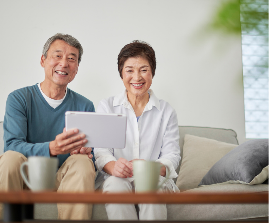 タブレットを見ながら墓じまいについて話し合うシニアのご夫婦