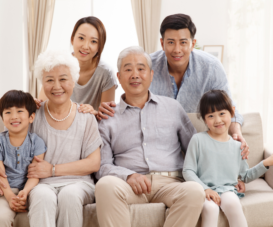 ソファで笑顔で寄り添う三世代の家族